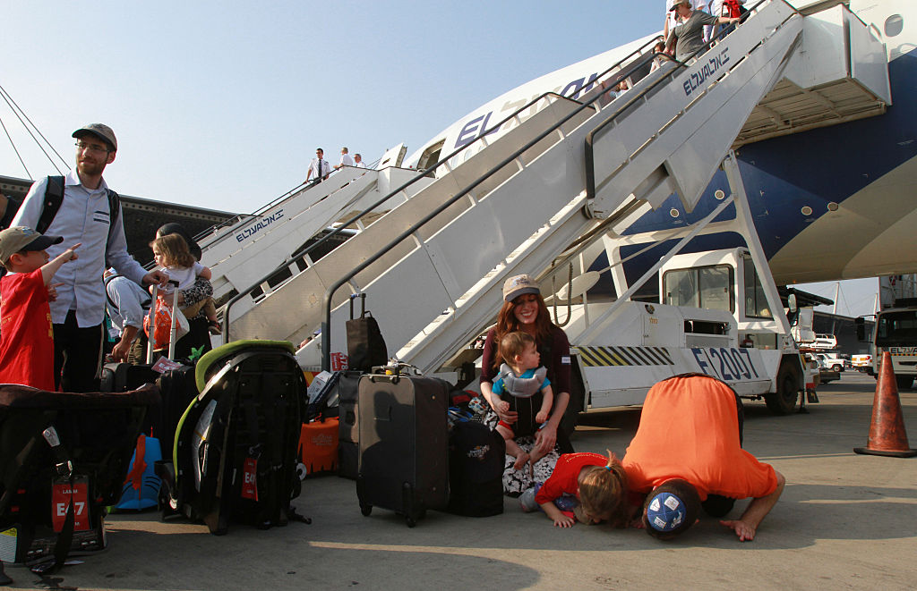 JERUSALEM, July 14, 2015-- New Jewish immigrants from North America kneel down upon their arrival at Ben Gurion Airport near Tel Aviv, Israel, on July 14, 2015. 221 new Jewish immigrants from North America arrived in Israel on Tuesday morning on a Nefesh B'Nefesh charter flight from New York's JFK Airport to Tel Aviv's Ben Gurion Airport. Ranging from 4 months old to 90 years old, the new immigrants include 32 families and 95 children. (Xinhua/Gil Cohen Magen via Getty Images)