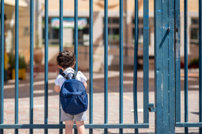 Child with bag back to school. Faceless cute little boy back to school with blue schoolbag.