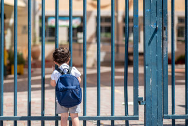 Child with bag back to school. Faceless cute little boy back to school with blue schoolbag.